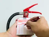 person checking the tag on a fire extinguisher